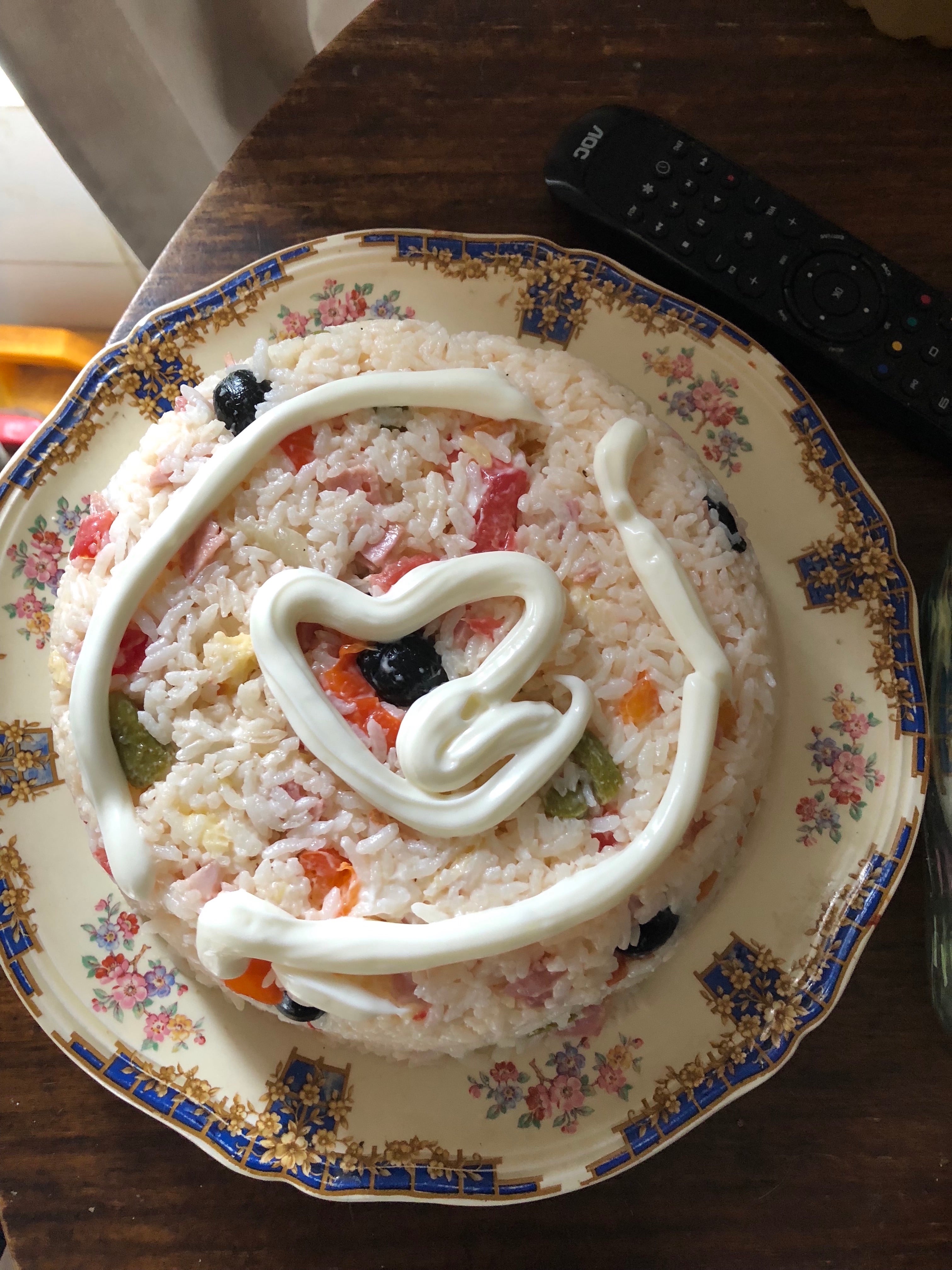 A dish of rice garnished with mayonnaise in the shape of a heart