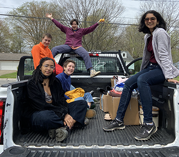 Students sit in the bed of a pickup truck