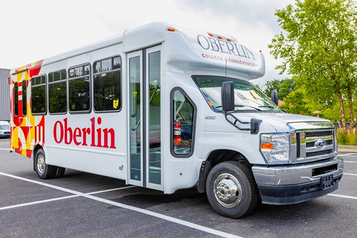 A small bus with 'Oberlin' on the side and a colorful pattern in back.
