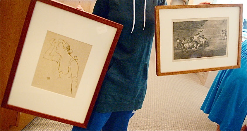 Alice holds up the two framed drawings