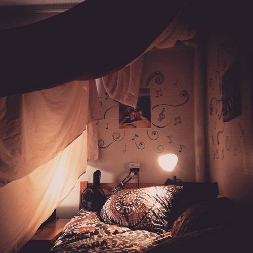 A cozy looking bed with dim lights