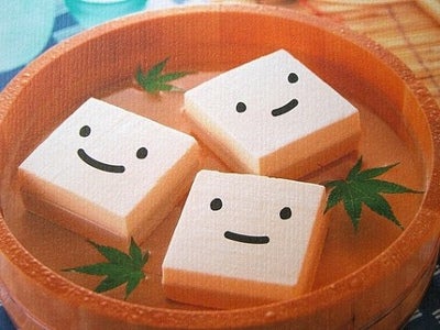 Blocks of tofu with smiley faces float in a bowl