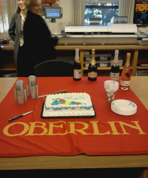 A cake and Champagne sits on an Oberlin cloth 