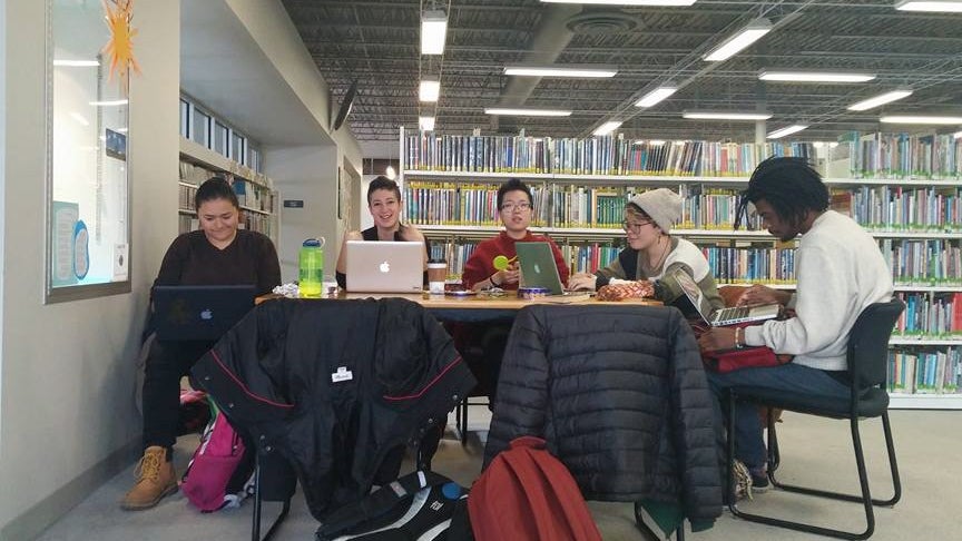 The group shares a table at the library