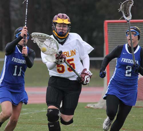 Oberlin women's lacrosse goalie running with the ball in a match