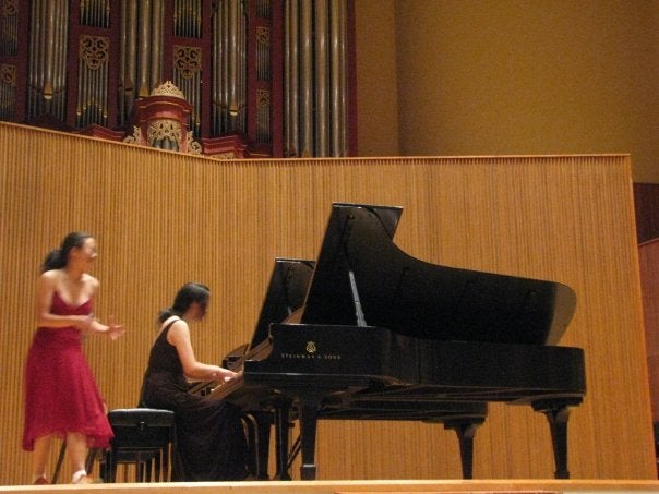 On stage, Juliette plays piano while Sophia looks a bit frantic.