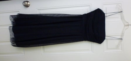 A shoulder-less black dress on a hanger