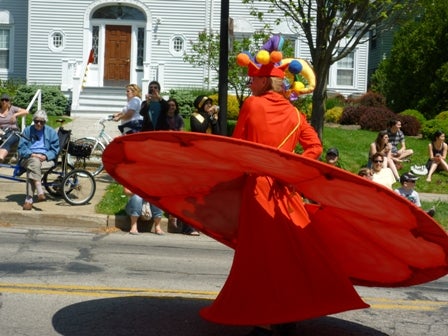 A whirling dervish passes by some parade watchers.