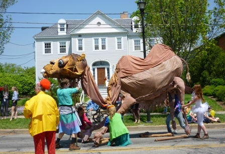 Several people move the elaborately-constructed camel.