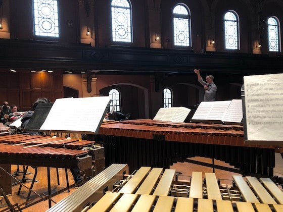 Marimbas, vibraphones, xylophones on stage at Finney Chapel, conductor up front.