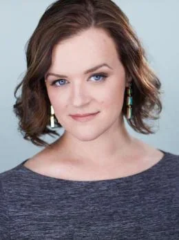 woman with shoulder length hair and gray sweater