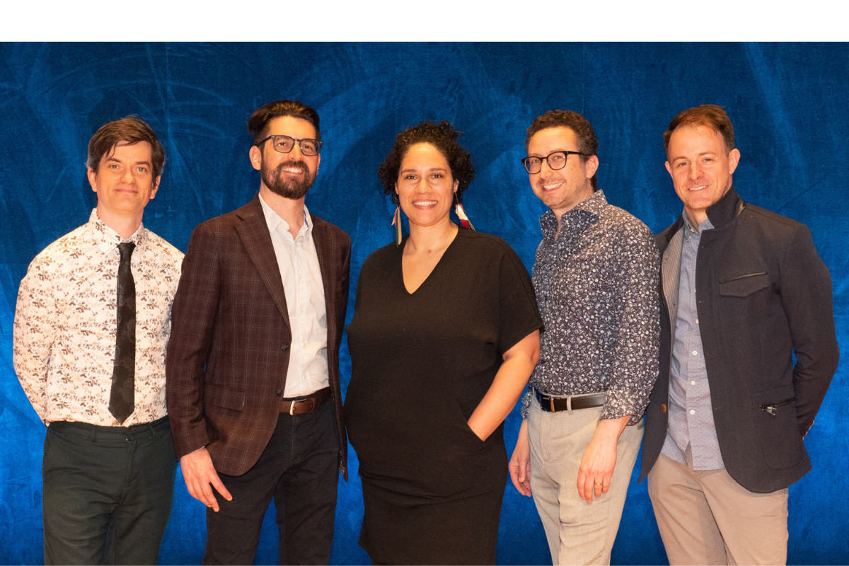 four men and one woman standing, smiling at the camera