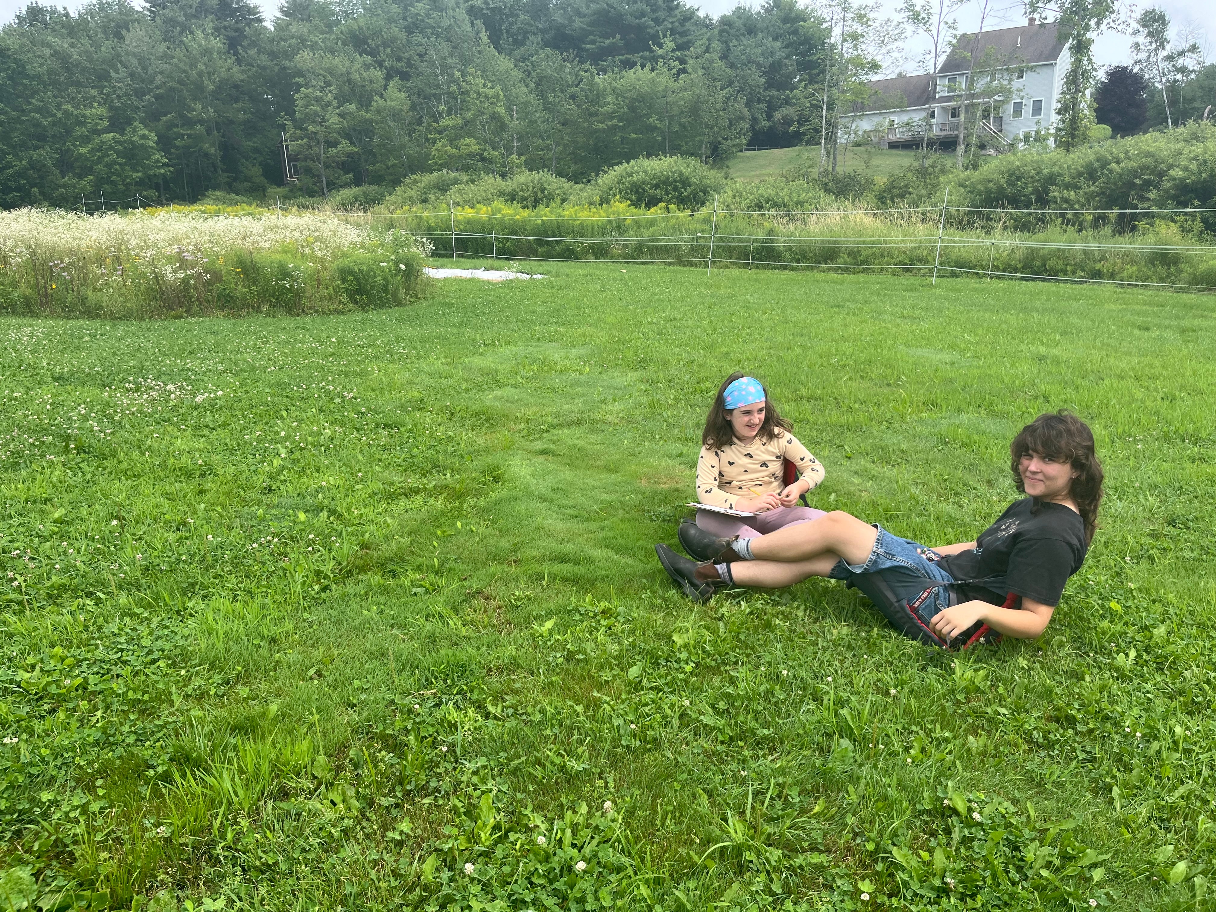 Woman and child sit in the grass.