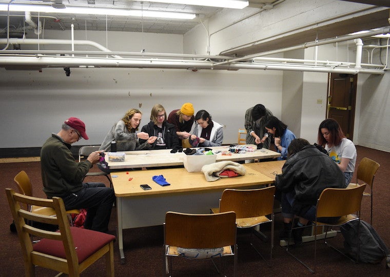 A group of students learn how to sew.