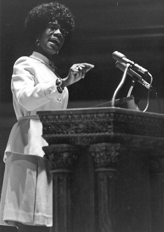 An African American woman speaks at a podium.