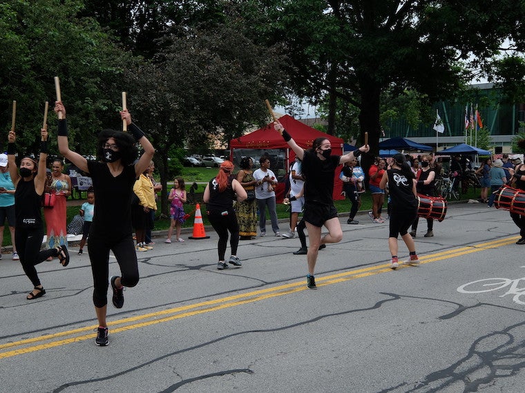 A student dance team performs in the street.