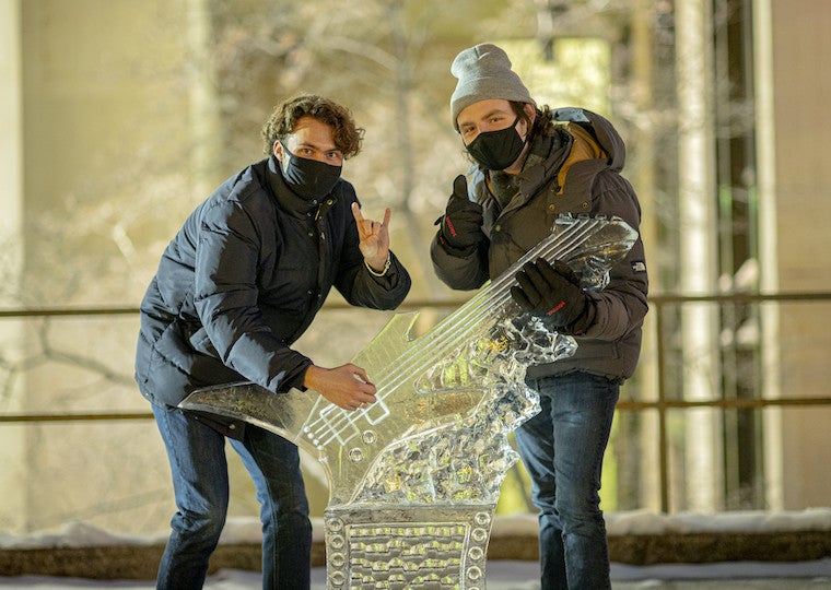 Two students pose next to a guitar carved out of ice.