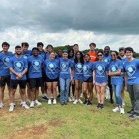 Group poses in field.