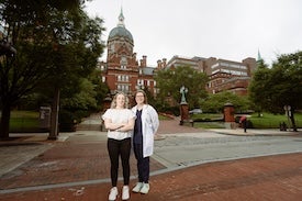 People pose outside building. 