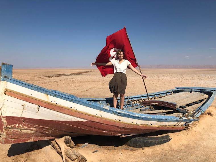 Student stands on a sailboat in a desert