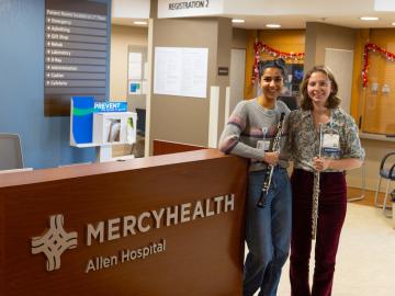 Two student musicians pose in Mercy Hospital lobby.