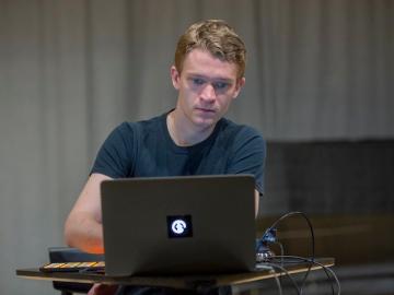 Electroacoustic artist Eli Stine ’14 works at a laptop computer.