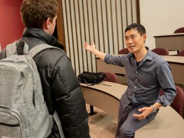 a student and professor have a lively conversation after class