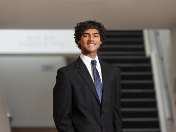 Portrait of Jesse Cruz in a suit smiling