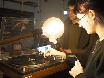 TIMARA student demonstrates a photosonic composition using a turntable and lightbulb.