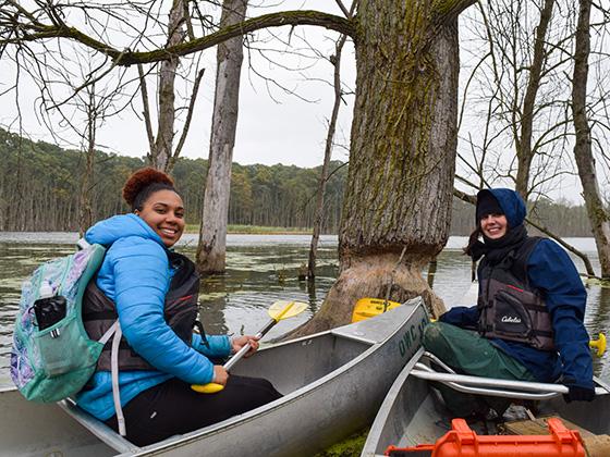 Two students prepare to set off in canoes.