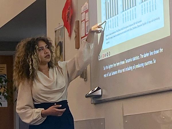 Amélie points to a slide during a presentation.