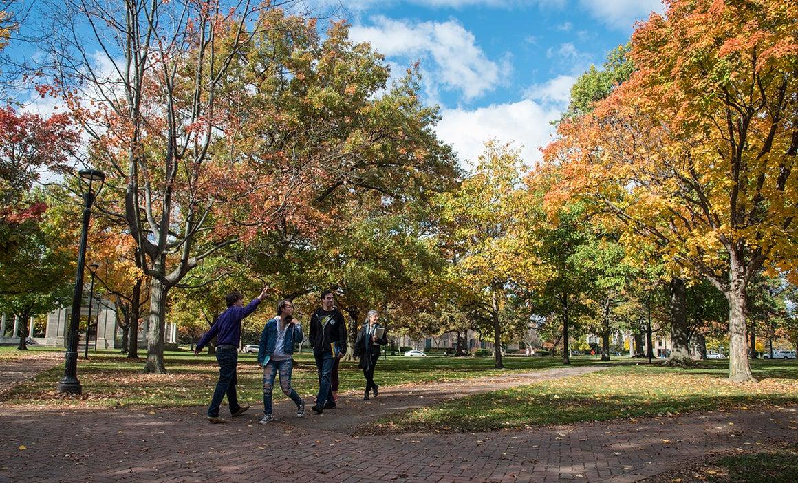 A family takes a campus tour amid fall foliage.