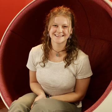 A female-identifying student in a white t-shirt.