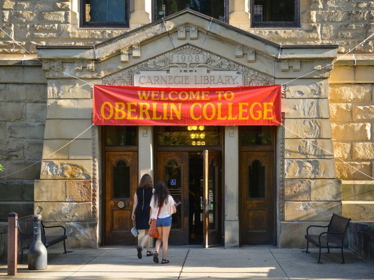 A new student and a family member walking into Carnegie Building.