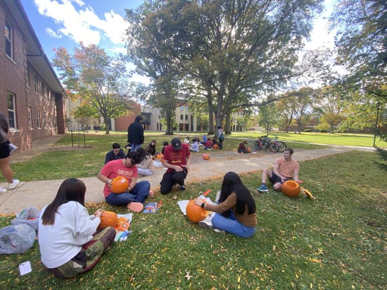 Students carving pumpkins outside