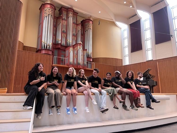 2024-25 Oberlin ConPALs, sitting on Finney Chapel stage