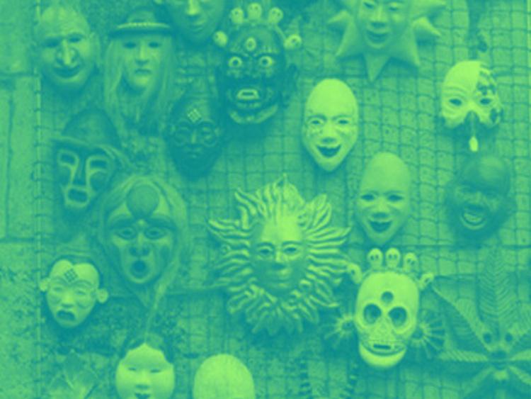 theatrical masks hang on a display wall