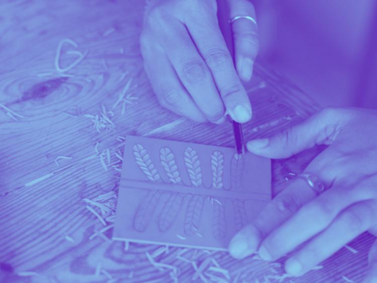 Close up of hands carving a stamp