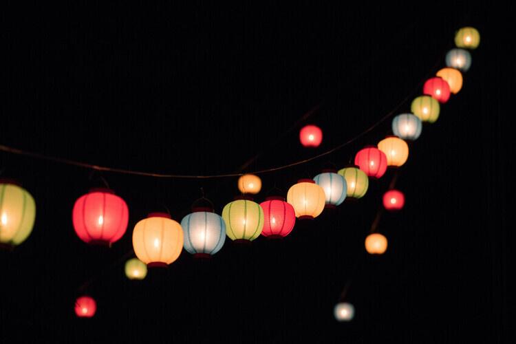 Multicolored lanterns glow in darkness