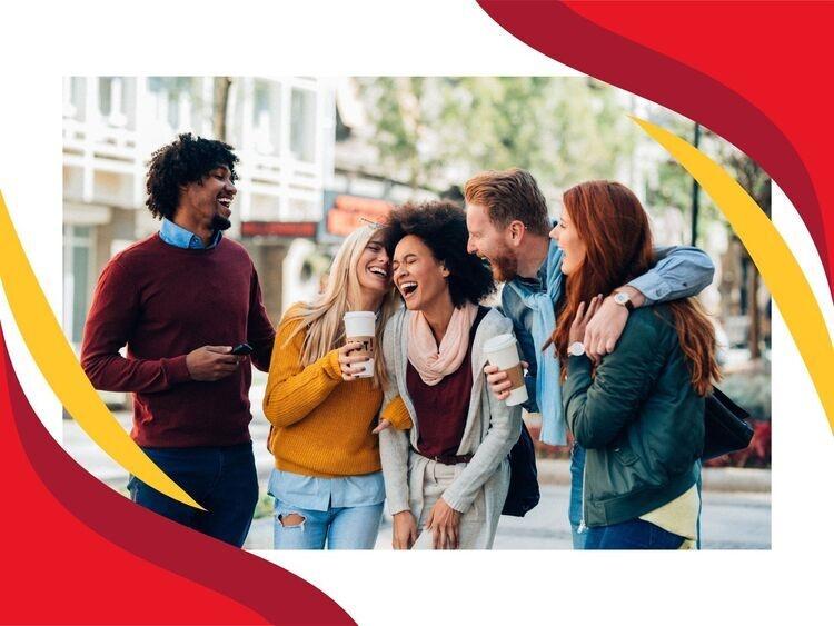 Friend group laughing on a sidewalk