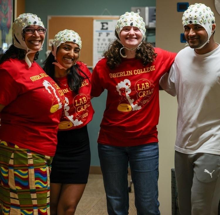 Four students with EEG caps on from Lab Crawl 2023. 