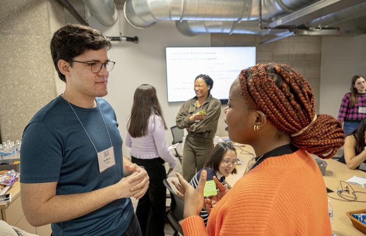 Two students talking in foreground during a session of ENGAGE 2023