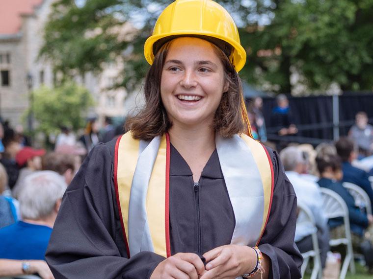 a student wearing a yellow hard hat at graduation